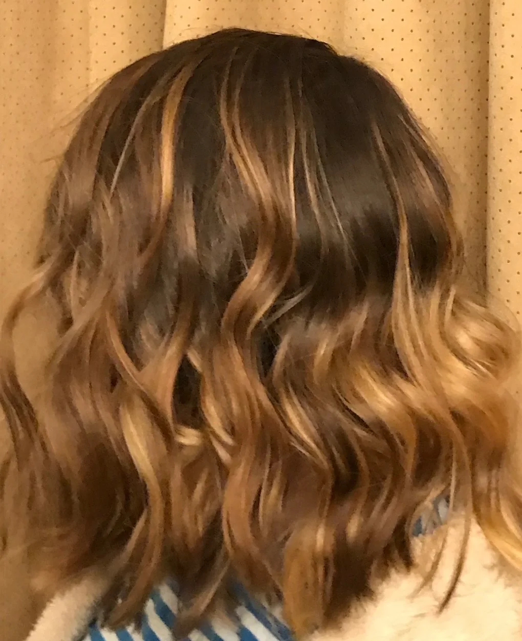 Warm caramel waves and dimensional brunette color, seen from behind